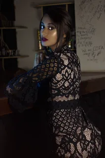 酒吧柜台附近穿着黑色蕾丝连衣裙的女人 酒吧柜台附近穿着黑色蕾丝连衣裙的女人