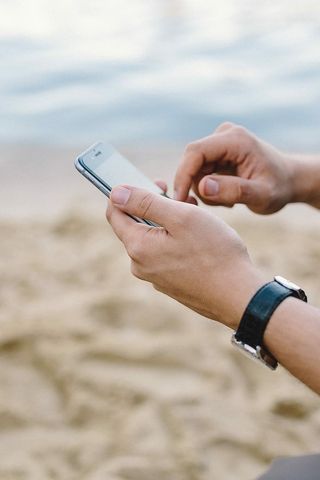 年轻人在海滩上用手机