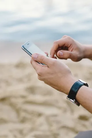 年轻人在海滩上用手机