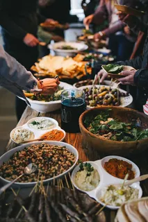 人们坐在摆满食物的餐桌旁 人们坐在摆满食物的餐桌旁