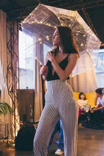 拿着透明雨伞站在建筑物内的女人 拿着透明雨伞站在建筑物内的女人