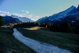 雪山附近绿草间的灰色小路
