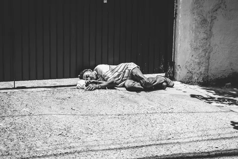 一名男子躺在大门旁的灰度照片