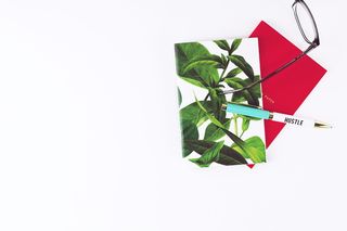 笔记本，钢笔，白色书桌，女老板，眼镜，白色背景，复印空间，叶子