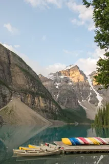 白天在湖和山附近的码头上划独木舟 白天在湖和山附近的码头上划独木舟