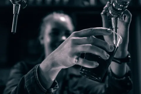 举着酒杯的人的灰度照片 举着酒杯的人的灰度照片
