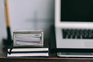 优雅的工作空间，配备Macbook、iPhone、名片和笔记本电脑