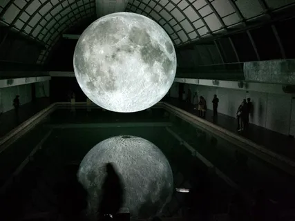 月亮全息图漂浮在房间内人员附近的水面上的照片 月亮全息图漂浮在房间内人员附近的水面上的照片
