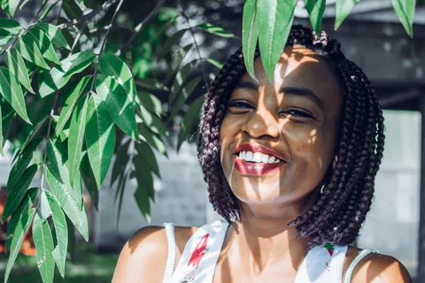 站在树下穿着白色上衣的女人