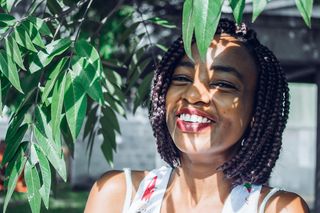 站在树下穿着白色上衣的女人