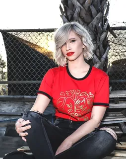 穿着红色圆领衬衫坐在长凳上的女人 穿着红色圆领衬衫坐在长凳上的女人