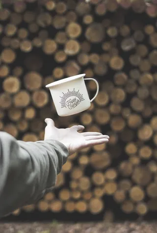 翻转印有Happy Camper印花的白色马克杯的人