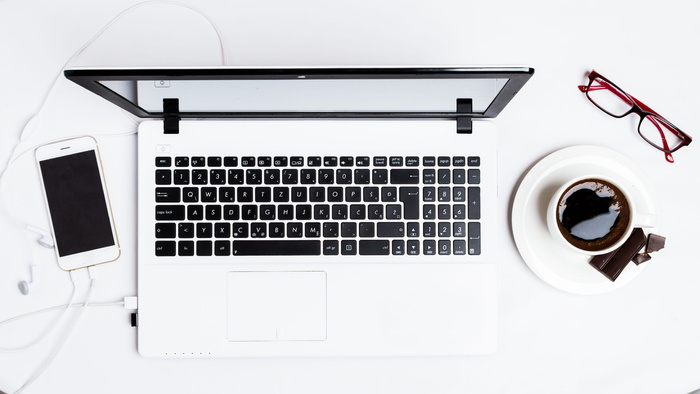 MacBook Pro介于智能手机和白色茶杯之间