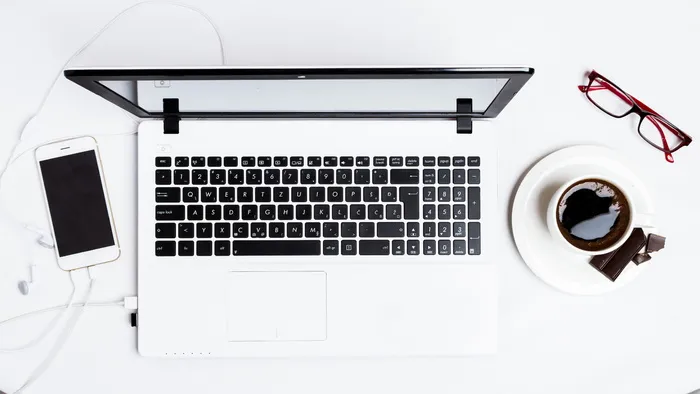 MacBook Pro介于智能手机和白色茶杯之间