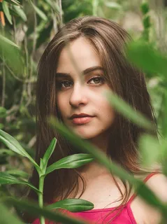 从树叶后面选择焦点拍摄一张身穿红色迷彩服的女士的俯视图 从树叶后面选择焦点拍摄一张身穿红色迷彩服的女士的俯视图