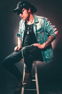 坐在椅子上穿着牛仔夹克的男子 坐在椅子上穿着牛仔夹克的男子