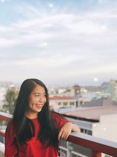 倚在阳台篱笆上微笑的女人 倚在阳台篱笆上微笑的女人