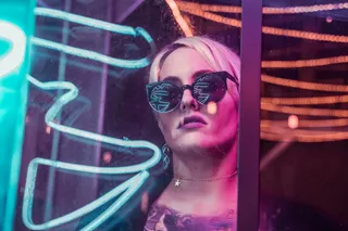 戴着黑色太阳镜透过玻璃的女人