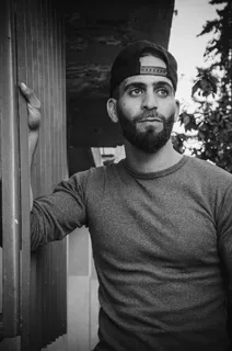 倚靠窗框的人的灰度照片