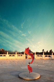 蔚蓝的天空下有女生在跳舞舞动着红色...