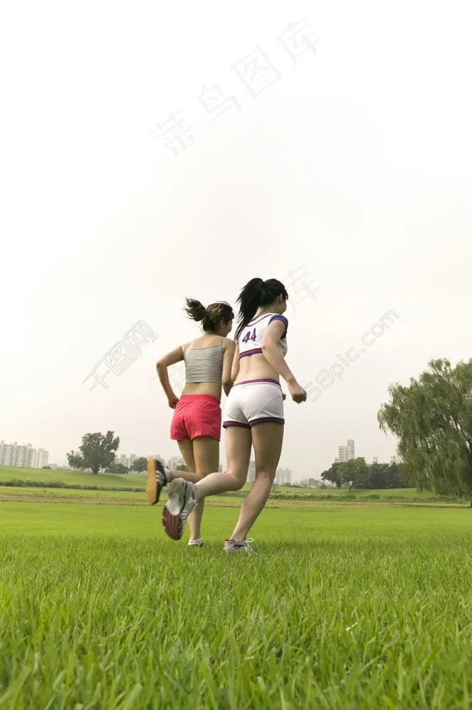 草坪上跑步的两个美女图片
