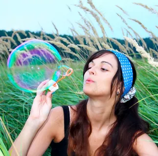 在草地上吹泡泡的美女图片 在草地上吹泡泡的美女图片