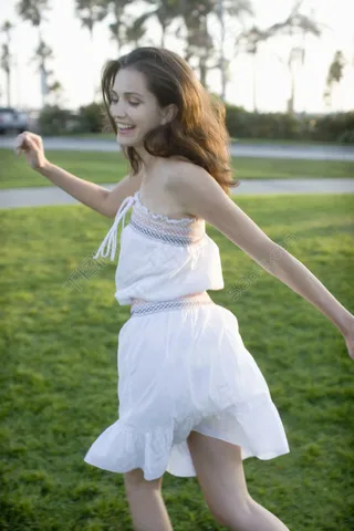 草地上奔跑的时尚美女图片