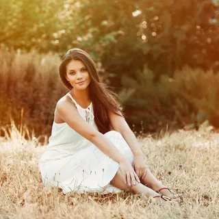 坐在草地上的白裙美女图片
