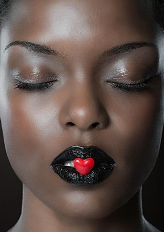 嘴含爱心糖果的美女图片