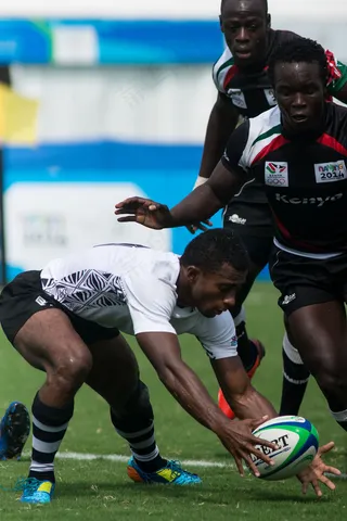 草地上抢橄榄球的运动员图片