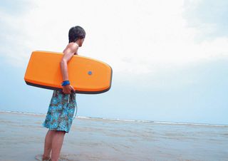 拿滑水板的男人背影图片