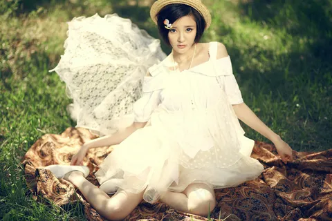 坐在草地上的美女图片