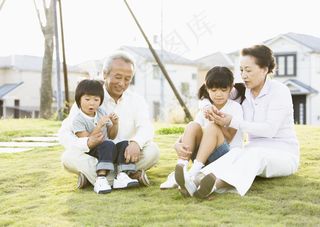 坐在草地上的祖孙四人图片