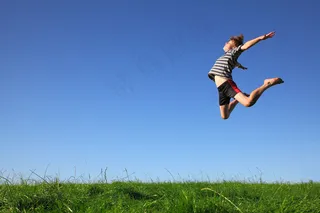 草地上跳跃的孩子图片