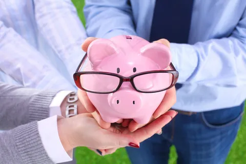 手拿储钱罐金币货币 理财保障商务金融财富增长主题 手拿储钱罐金币货币 理财保障商务金融财富增长主题