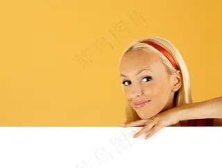 扶着空白广告牌的微笑美女图片