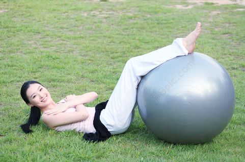 躺在草地上做运动的瑜伽少女图片图片