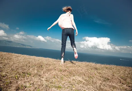 行走在草地上的美女背影图片