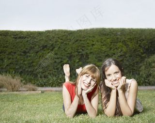 趴在草地上的时尚美女图片
