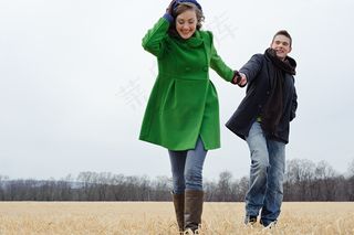 一对幸福恋人手牵手的走在草地上图片