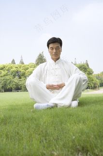 草地上打座的中年师傅图片图片