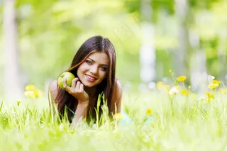 拿着苹果在草地上的美女图片