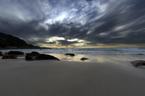夕阳大海沙滩礁石图片
