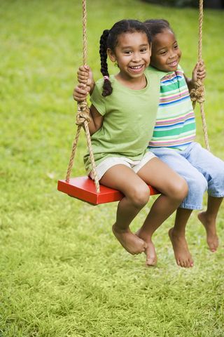 草地上荡秋千的两个外国小孩图片