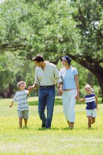 手牵手走在草地上的一家人图片