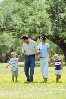 手牵手走在草地上的一家人图片