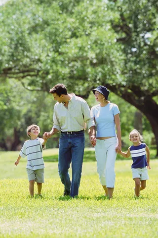 手牵手走在草地上的一家人图片