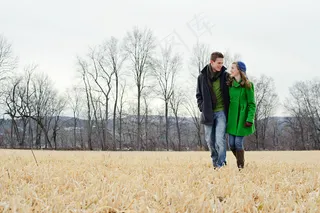 一对幸福恋人行走在枯萎的草地上图片