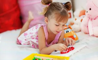 趴着玩玩具的小女孩图片