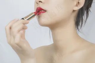 正在涂口红的女性商用摄影图